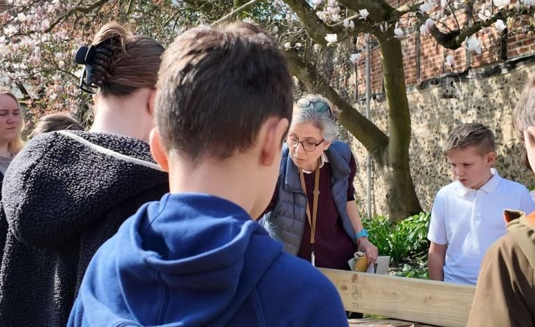 School children gather around a table, creating their contributions