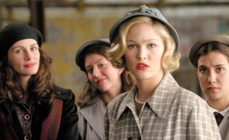 4 women in vintage clothing look to camera