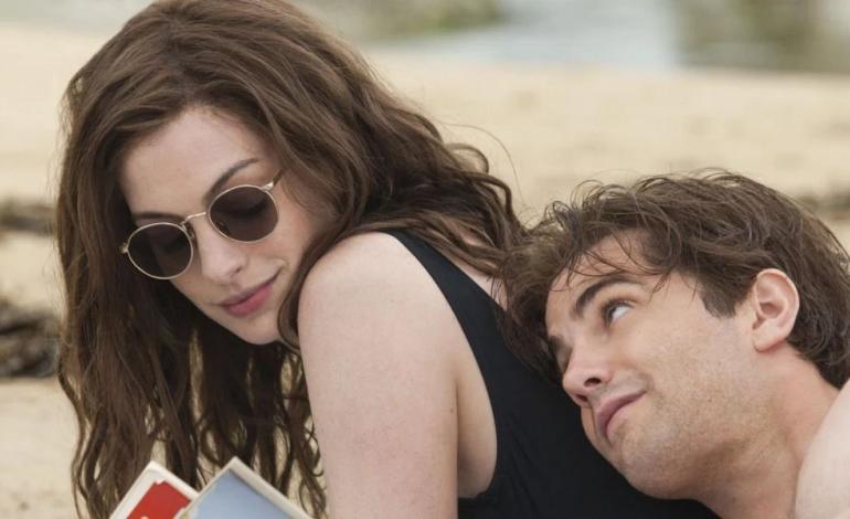 a man and a woman snuggling on a beach