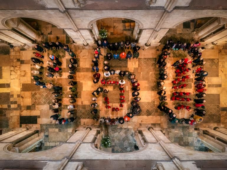 People stand in the shape of 950 in the Cathedral nave