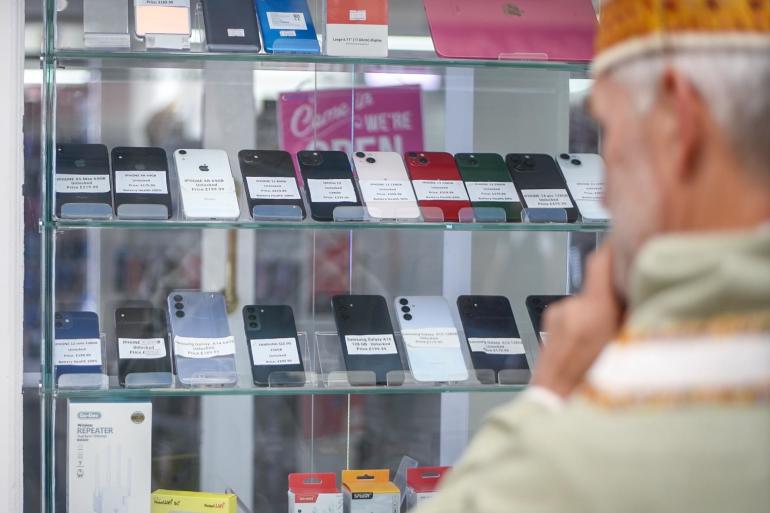 St Richard looking in a mobile phone shop window 