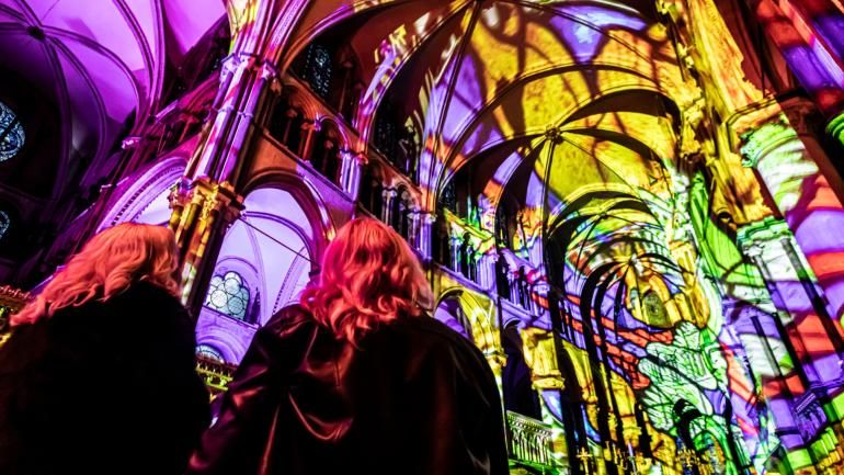 Two people looking up at colours projected inside the Cathedral